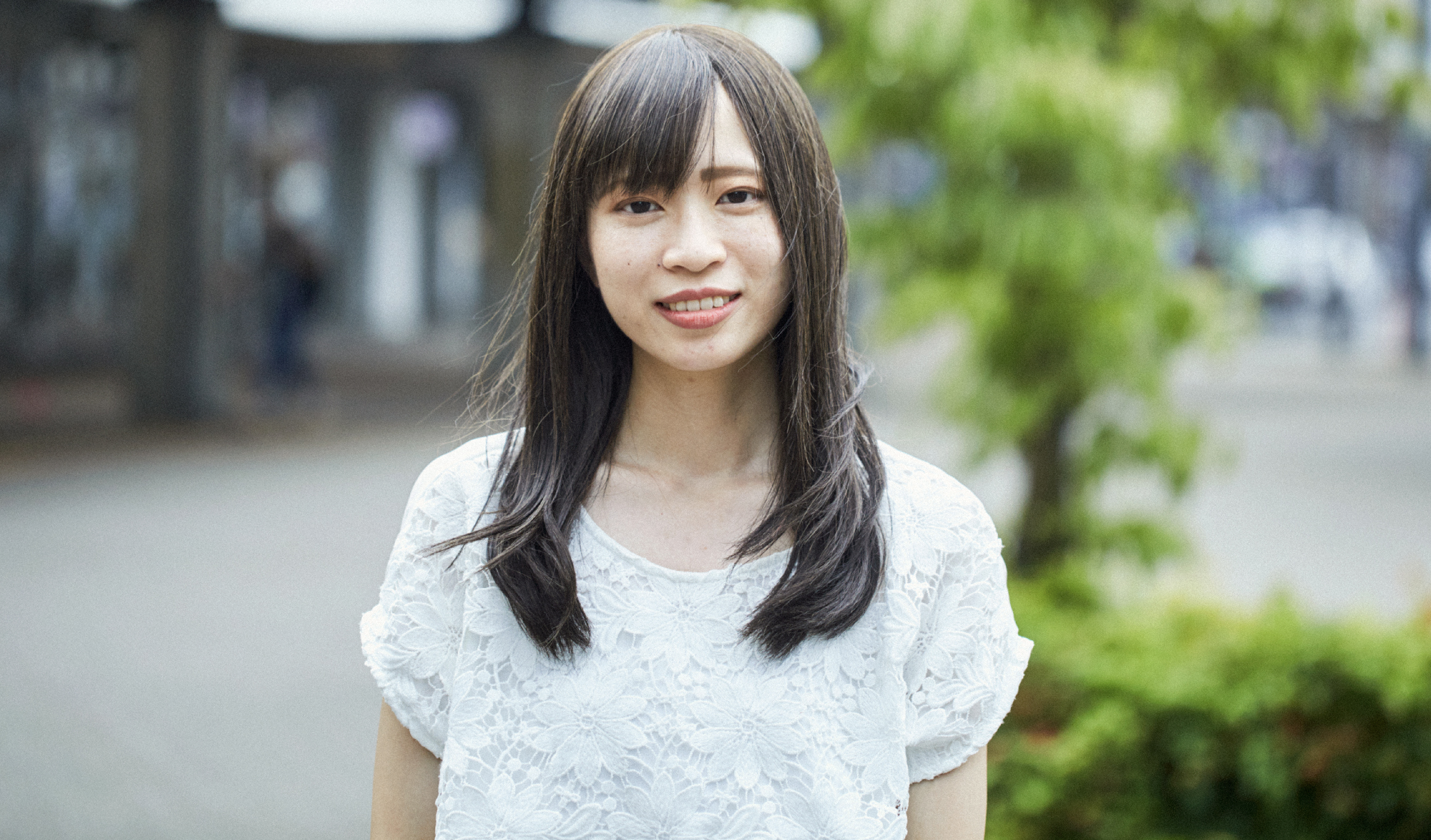 街で女性がカメラ目線でこちらを見ている