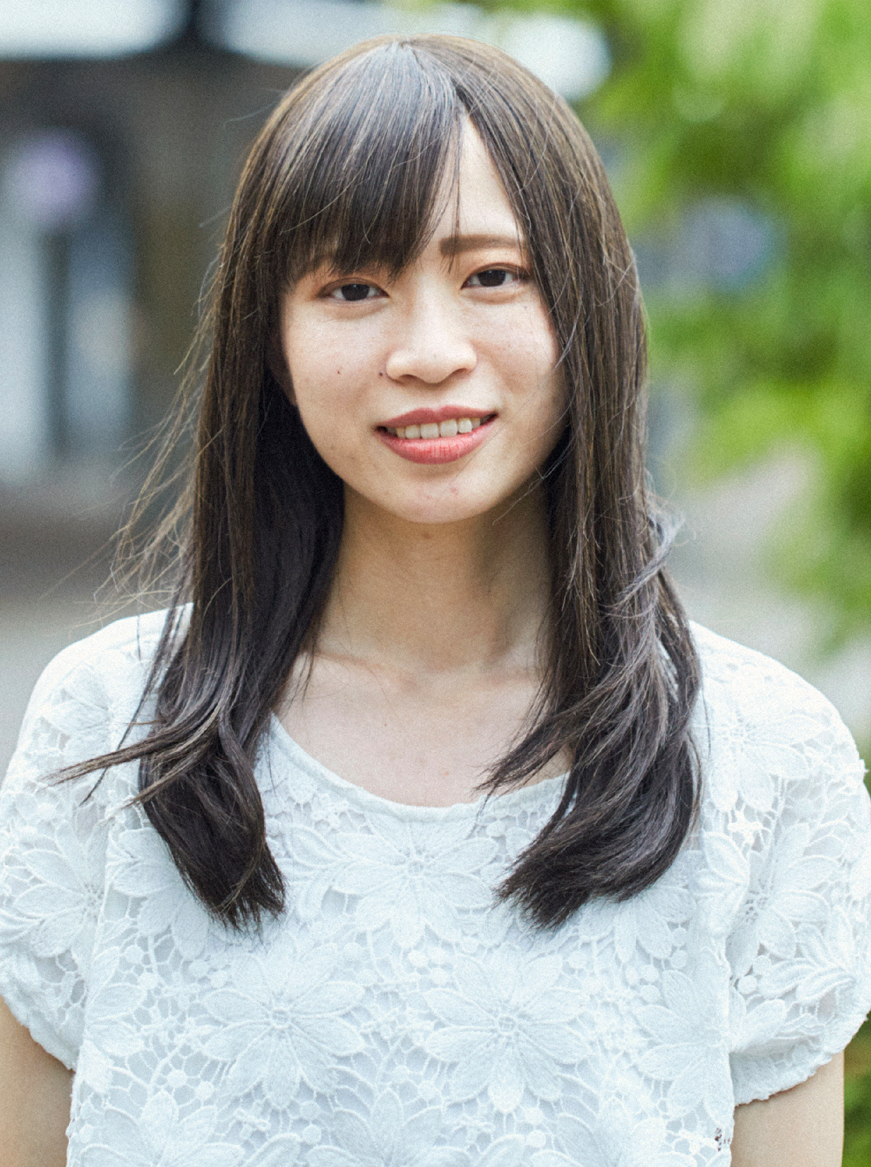 街で女性がカメラ目線でこちらを見ている