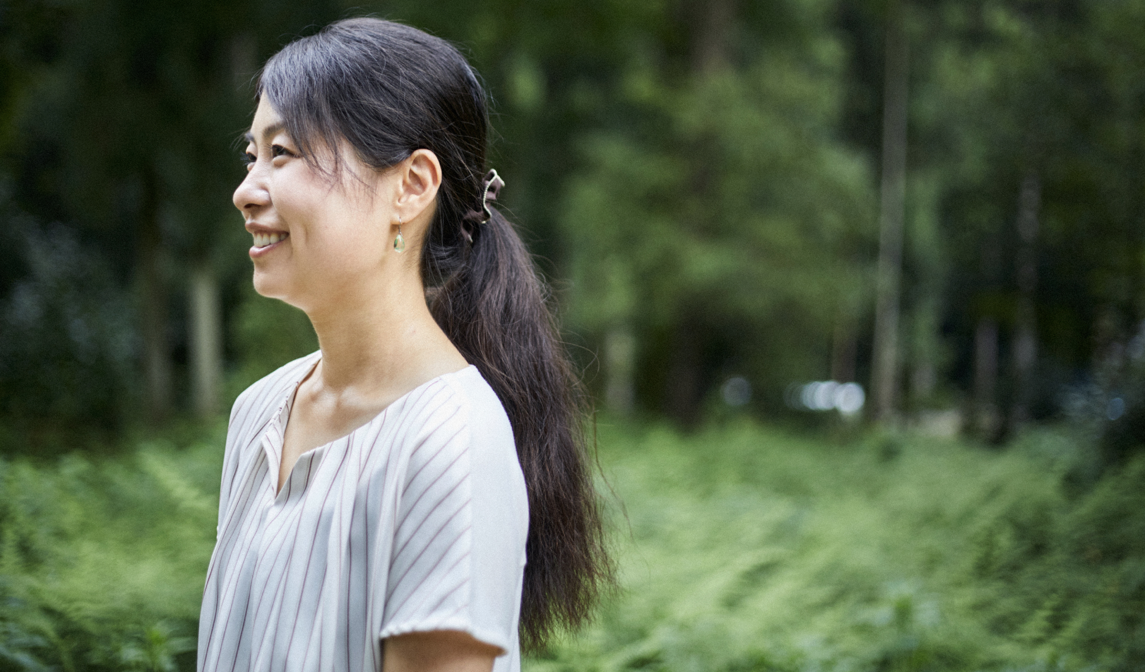 林の中で女性が左側を向いている