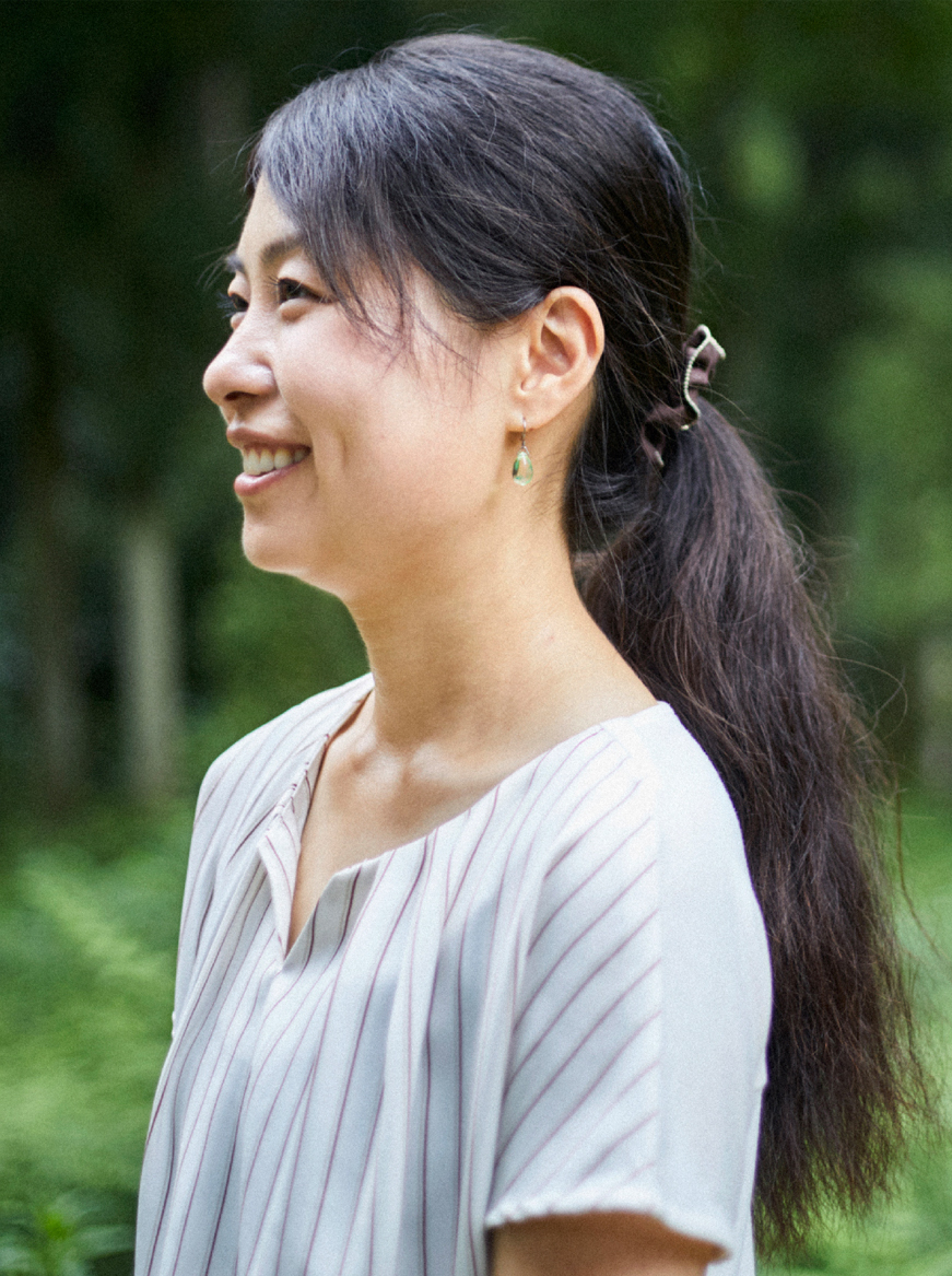 林の中で女性が左側を向いている